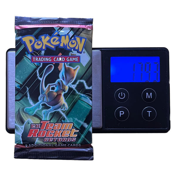 A sealed Pokémon TCG: EX Team Rocket Returns Booster Pack - Heavy (EX Ruby & Sapphire) by The Pokémon Company with Mewtwo art sits on a scale, weighing 17.93g and possibly containing rare cards among its 9 game cards.