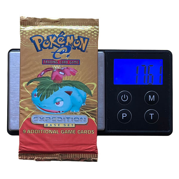 A sealed Pokémon TCG: Expedition Booster Pack - Heavy (eSeries) by The Pokémon Company, featuring Venusaur artwork, is displayed on a digital scale reading 17.61g; the pack advertises 9 additional game cards and may contain a rare holo kort.